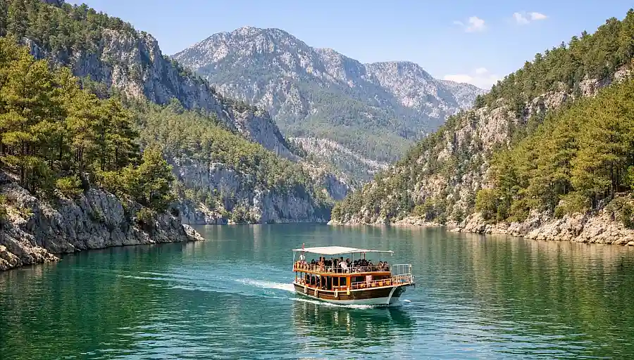 Boat on the calm green waters of Green Canyon near Manavgat, surrounded by pine-covered hills